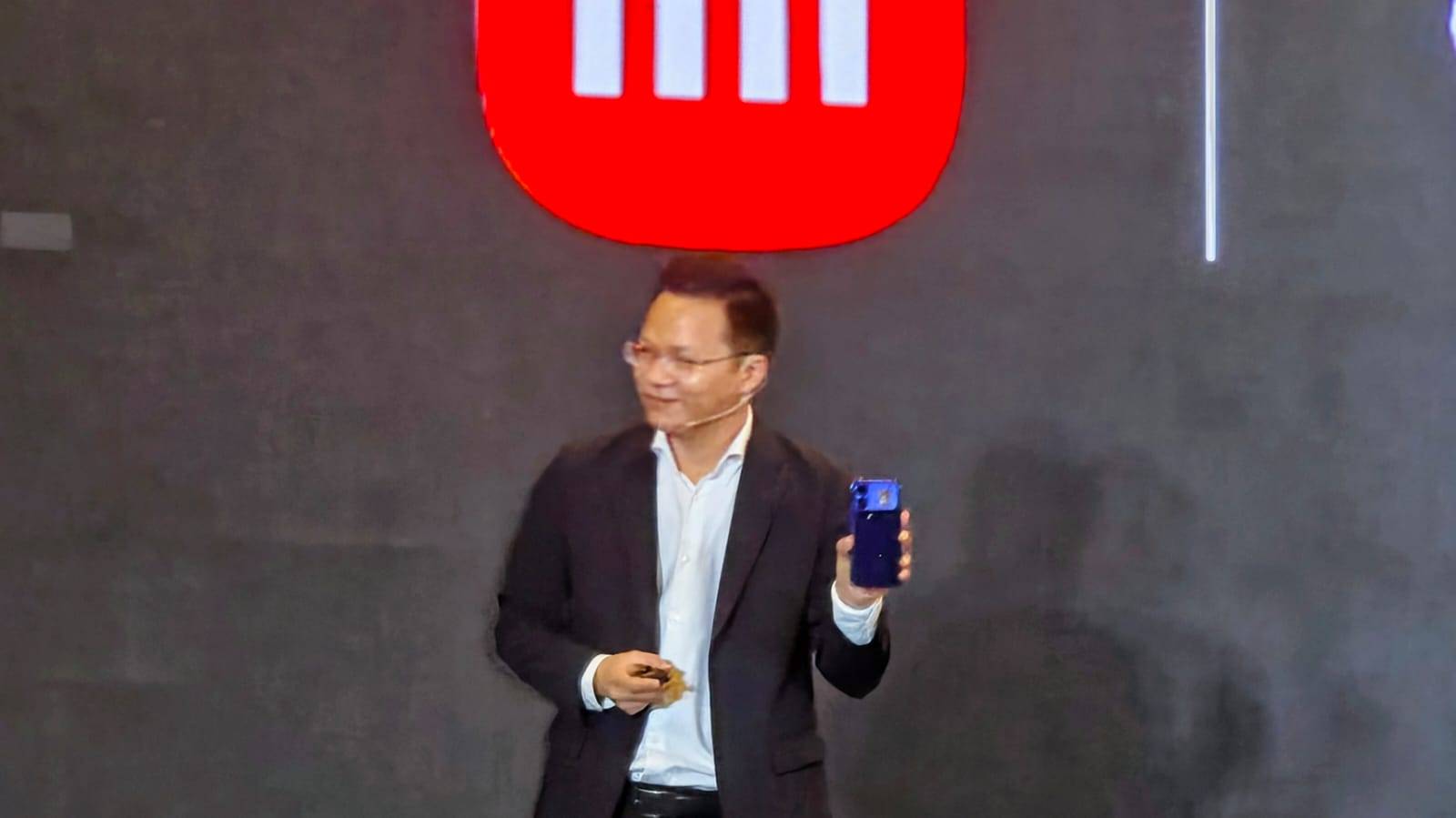 Country Director Xiaomi Indonesia, Michael Feng, memamerkan Xiaomi 18 Pro Max di atas panggung.